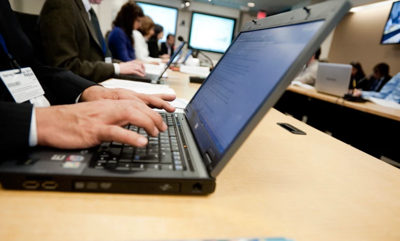 Hands typing on a laptop computer