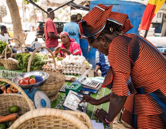 Woman in a market using a mobile device Woman in a market using a mobile device