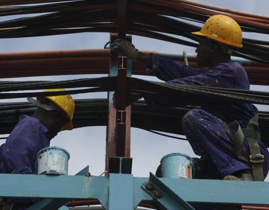 Construction workers working on beams Construction workers working on beams